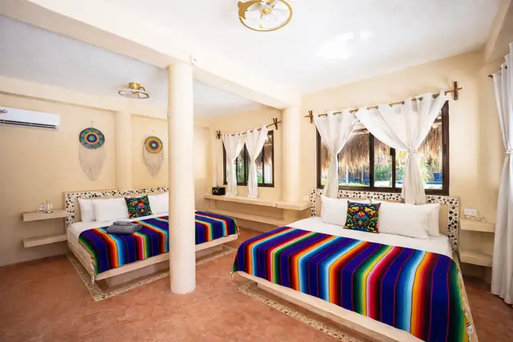 Atenea Double King room with two king beds, sheer curtains and columns