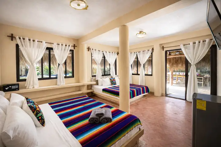 Atenea Double King room with two king beds and glass doors to the garden
