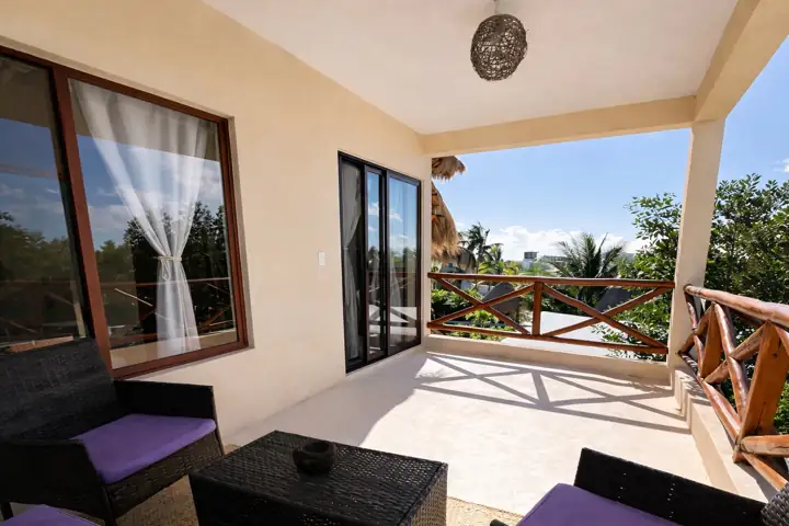 Covered balcony with wicker sofas and tree views