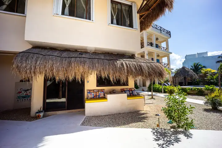 Exterior of Atenea Holbox with thatched palapa bar and three-storey guest building
