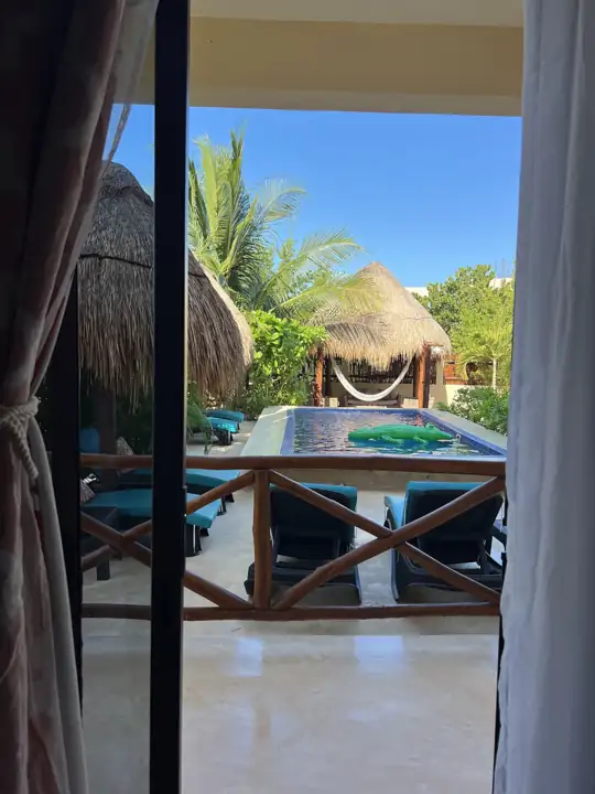 View from the Frida Room balcony over the swimming pool and thatched palapas