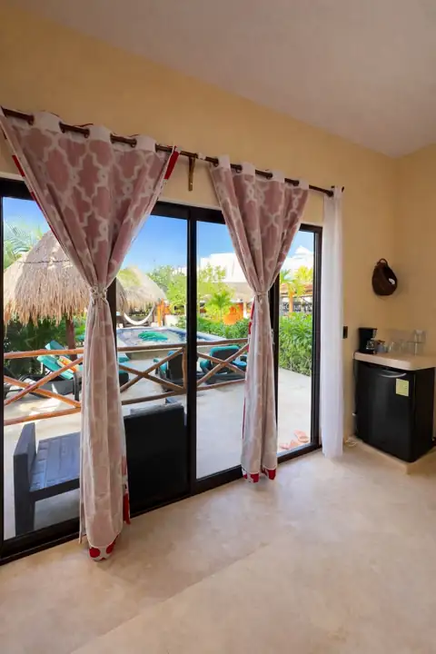 Guest suite with mini fridge and coffee maker opening onto the pool balcony