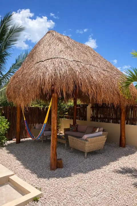 Garden palapa with hammock and outdoor sofa on the gravel terrace