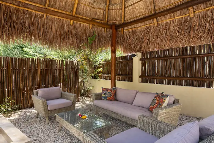 Wicker lounge under the garden palapa at Atenea Holbox
