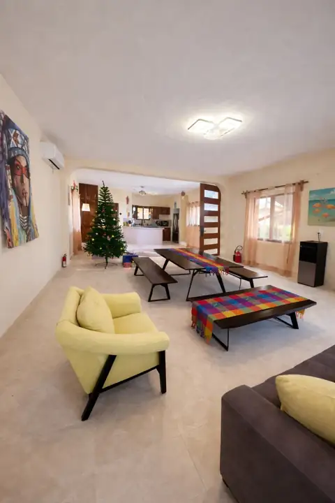 Main living room of Building 2 with yellow armchairs and long dining table
