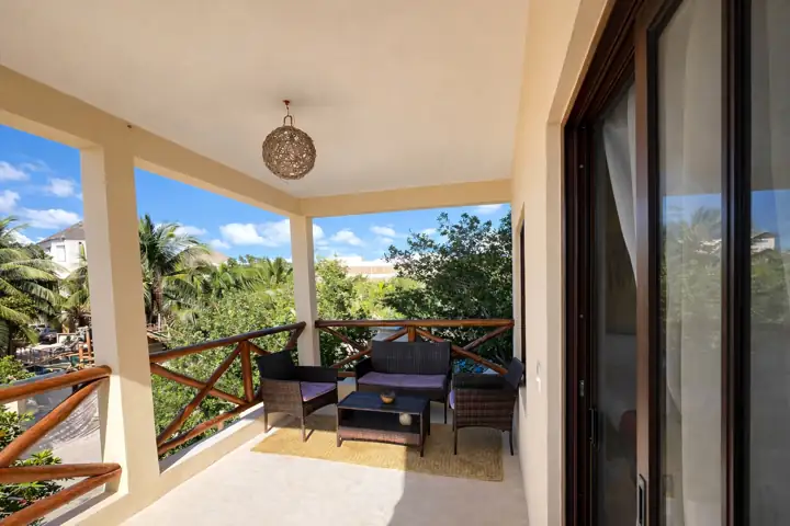 Luma Suite private balcony with wicker sofa overlooking the garden
