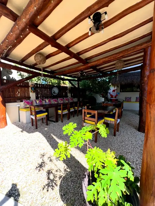 Outdoor dining palapa seen through the tropical garden