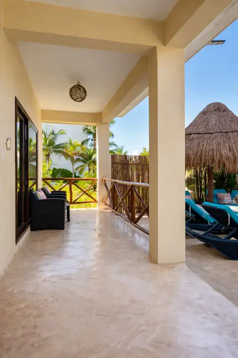 Covered pool terrace with loungers and sea breeze at Atenea Holbox