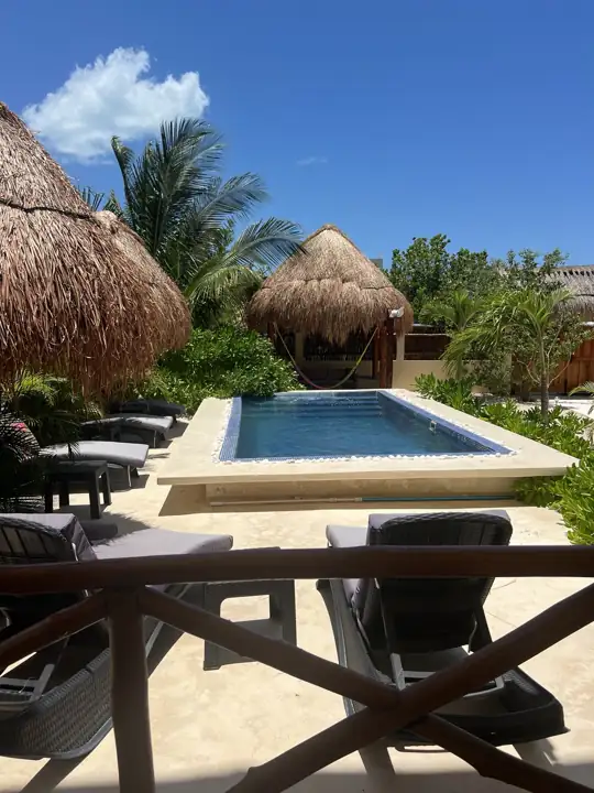 Swimming pool and palapas seen from the covered terrace