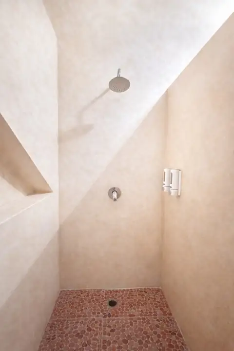Polished-cement walk-in rain shower in a guest bathroom at Atenea Holbox